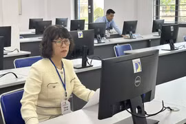 Cán bộ coi thi đánh giá tư duy kiểm tra máy tính trước giờ thi. (Ảnh: PV/Vietnam+)