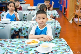 Các em học sinh Hà Nội ăn bữa tối tại trường ngày 30/9 vì bão số 10. (Ảnh: NTCC)