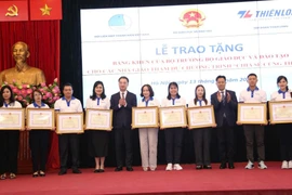Thứ trưởng Bộ Giáo dục và Đào tạo Lê Quân và Bí thư Trung ương Đoàn Nguyễn Tường Lâm tặng bằng khen cho các giáo viên. (Ảnh: PV/Vietnam+)