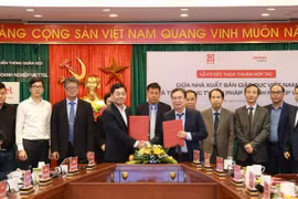 Ông Nguyễn Tiến Thanh - Chủ tịch Hội đồng thành viên, Tổng giám đốc Nhà xuất bản Giáo dục Việt Nam và ông Nguyễn Chí Thanh – Phó Tổng Giám đốc Tổng công ty Giải pháp Doanh nghiệp Viettel trao đổi văn bản thoả thuận hợp tác giữa hai đơn vị. (Ảnh: PV/Vietnam+)