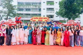 Sinh viên quốc tế hào hứng trải nghiệm Tết Việt trong trang phục áo dài truyền thống của người Việt Nam. (Ảnh: PV/Vietnam+)