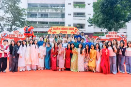 Sinh viên quốc tế hào hứng trải nghiệm Tết Việt trong trang phục áo dài truyền thống của người Việt Nam. (Ảnh: PV/Vietnam+)