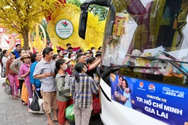 Người dân về quê đón Tết trên các chuyến xe miễn phí. (Ảnh: PV/Vietnam+)