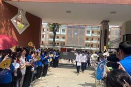 Những thí sinh đầu tiên hào hứng bước ra khỏi điểm thi tại Trường Trung học phổ thông Trương Định sau khi hết giờ thi môn Ngữ văn. (Ảnh: Trung Hiền/Vietnam+) 