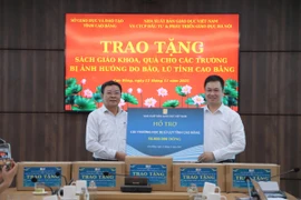 Ông Ngô Văn Hoan - Phó Tổng Giám đốc Nhà xuất bản Giáo dục Việt Nam trao tặng tiền cho các trường học bị lũ lụt tỉnh Cao Bằng. (Ảnh: PV/Vietnam+)