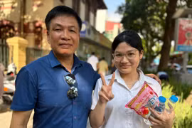 Nguyễn Mai Anh, học sinh Trường Trung học cơ sở Bồ Đề và bố sau giờ thi môn Ngoại ngữ. (Ảnh: Phạm Mai/Vietnam+)