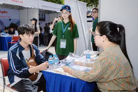 Sinh viên Trường Quản trị và Kinh doanh, Đại học Quốc gia Hà Nội trao đổi tìm hiểu về cơ hội việc làm. (Ảnh: PV/Vietnam+)