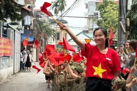 Các giáo viên trong trang phục cờ đỏ sao vàng dẫn đầu các đoàn học sinh trong trang phục các lực lượng quân đội nhân dân Việt Nam. (Ảnh: PV/Vietnam+)