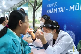 Các bác sỹ khám sức khoẻ miễn phí cho người dân. (Ảnh: PV/Vietnam+)