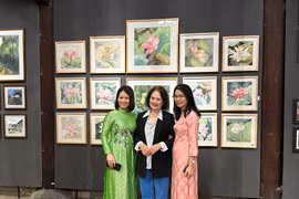 Khách tham quan chụp ảnh cùng các tác phẩm tại triển lãm. (Ảnh: Minh Ngọc/Vietnam+).