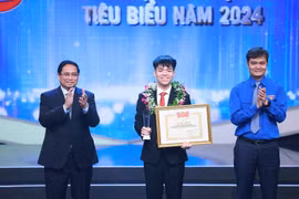 Thủ tướng Phạm Minh Chính và Bí thư thứ nhất Trung ương Đoàn Bùi Quang Huy trao Giải thưởng Gương mặt trẻ Việt Nam tiêu biểu cho em Nguyễn Tiến Hưng. (Ảnh: Dương Giang/TTXVN).