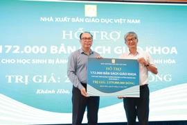 Ông Đặng Thanh Hải, Phó Tổng Giám đốc Nhà xuất bản Giáo dục Việt Nam trao tặng sách giáo khoa cho tỉnh Khánh Hòa. (Ảnh: Công Duy/Vietnam+)