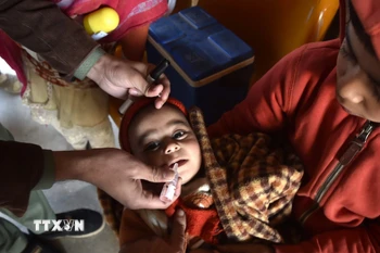 Em nhỏ uống vaccine phòng bại liệt tại Peshawar (Pakistan). (Ảnh: THX/TTXVN)