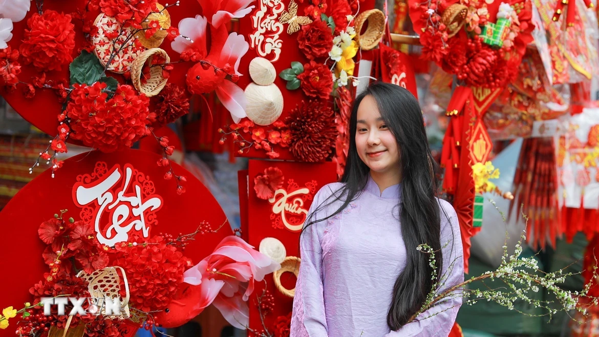 Người dân lưu lại khoảnh khắc tại chợ hoa Hàng Lược. (Ảnh: Khánh Hòa/TTXVN)