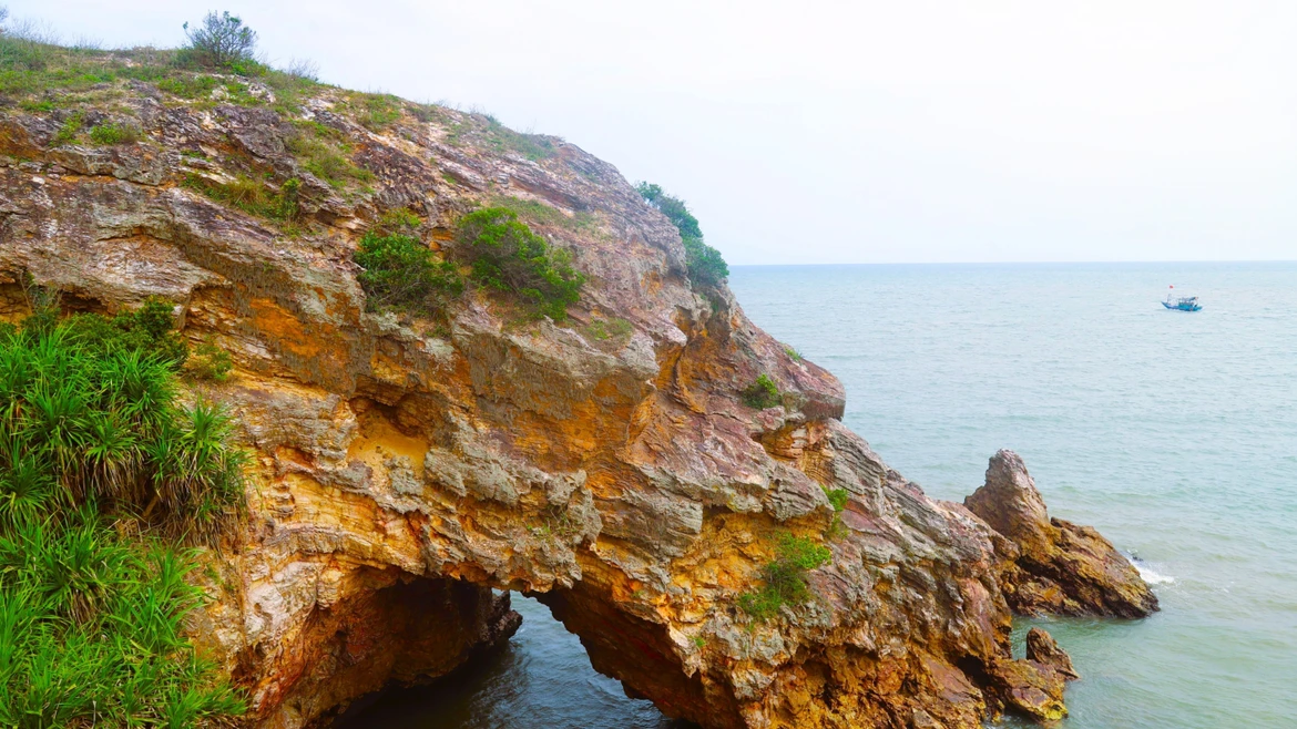 Nhìn từ trên cao, khu vực hang Mũi Trâu như một khuôn mặt người đang nhìn ra biển, cửa hang ngập trong nước khi thủy triều dâng cao. (Ảnh: Xuân Tiến/TTXVN)