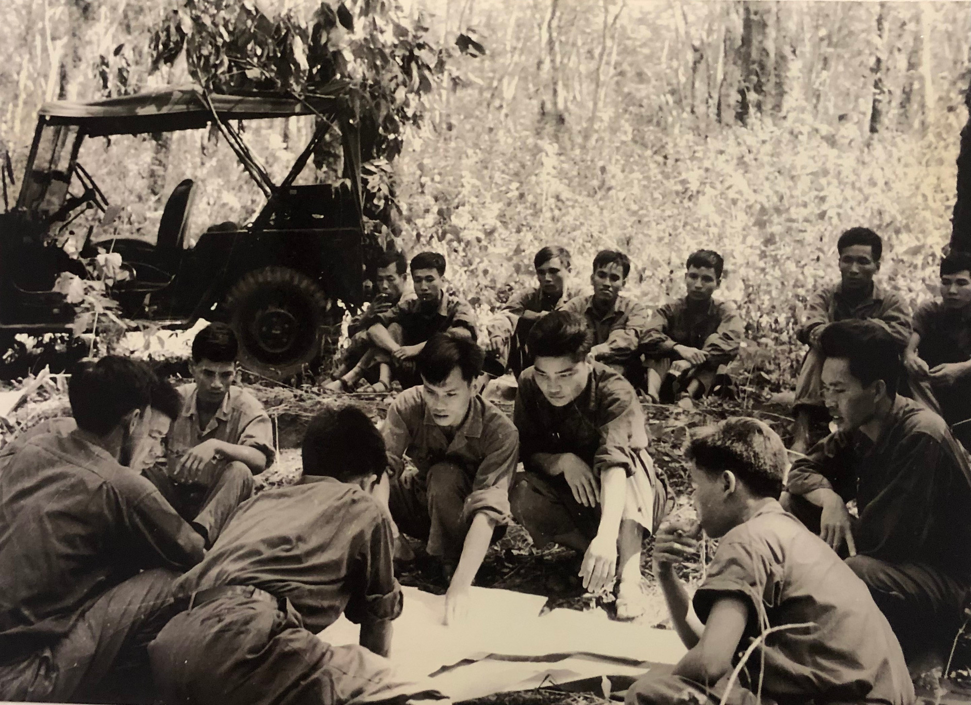 Giữa đồn điền cao su Ông Quế, Ban chỉ huy Trung đoàn Khe Sanh, Sư đoàn 304 trải tấm bản đồ do nhà báo TTXVN Đinh Quang Thành tặng để nghiên cứu từng tuyến đường vào Sài Gòn trong chiến dịch Hồ Chí Minh, tháng 4/1975. (Ảnh Tư liệu TTXVN) 1812-su-doan-304-9.jpg