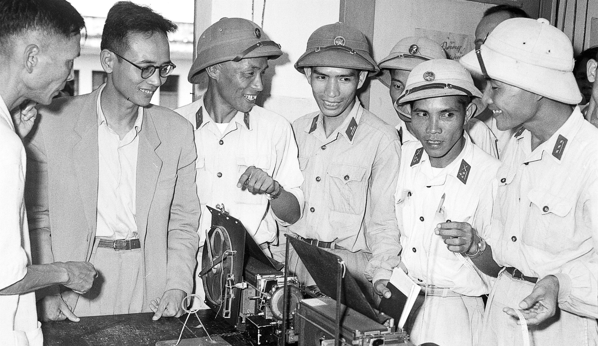 Cán bộ Sư đoàn 304 thăm VNTTX những ngày mới kết nghĩa, nghe giới thiệu về máy phát tin ảnh hiện đại nhất lúc bấy giờ do cán bộ, kỹ sư VNTTX lắp đặt. (Ảnh tư liệu TTXVN) 1812-su-doan-304-5.jpg