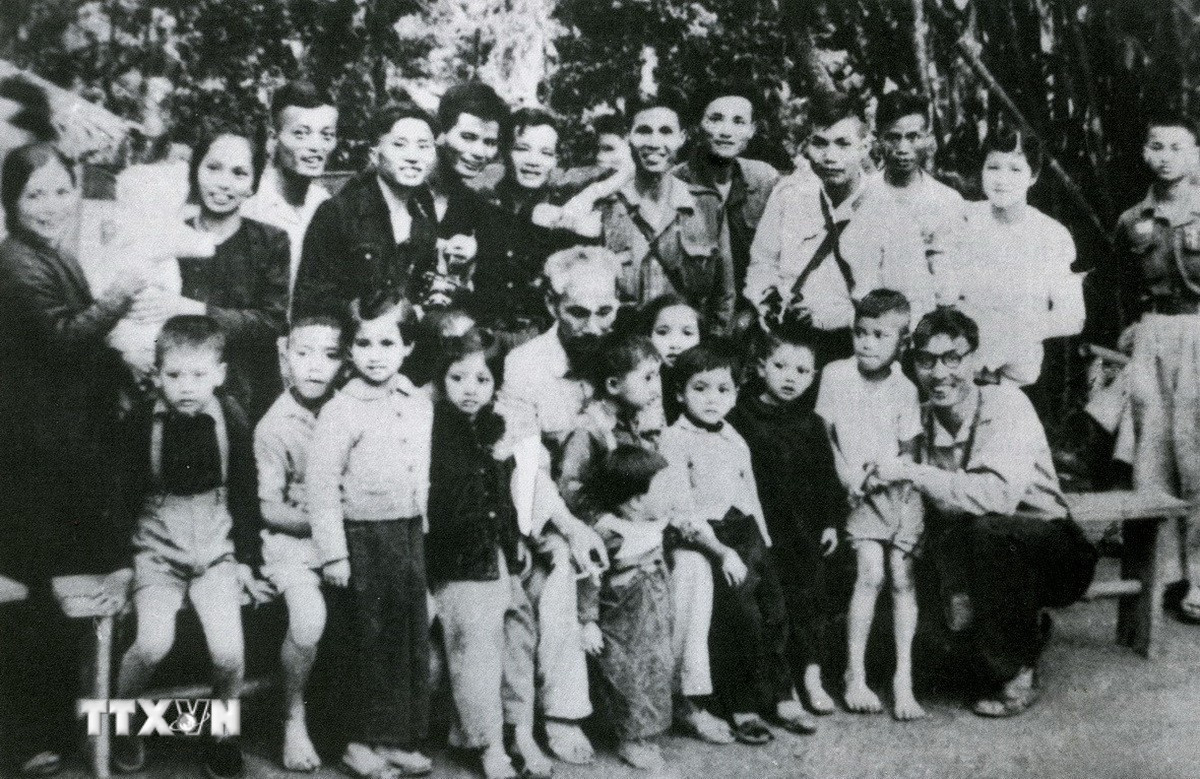 Năm 1952, Bác Hồ thăm cơ sở VNTTX tại Sơn Dương, Tuyên Quang và căn dặn cán bộ, phóng viên "Tin tức càng nhanh, kháng chiến càng mau thắng lợi." Trong ảnh: Bác Hồ chụp ảnh với các gia đình cán bộ Việt Nam Thông tấn xã trong thời kỳ kháng chiến chống Pháp tại Tuyên Quang (1952). (Ảnh: Tư liệu TTXVN) ttxvn-0409-chu-tich-ho-chi-minh-voi-15.jpg