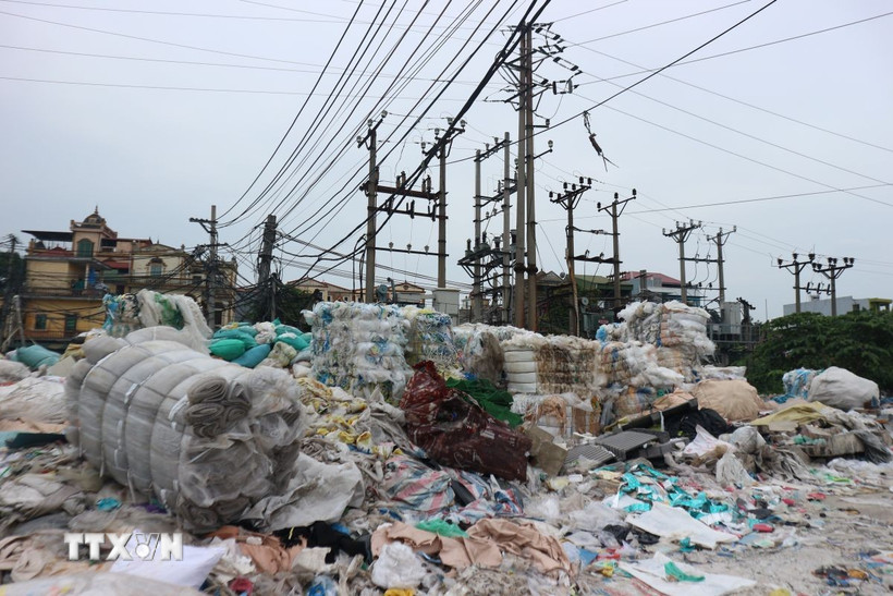 Trạm biến áp điện ở làng nghề Minh Khai bị rác thải nhựa quây kín, tiềm ẩn nguy cơ cháy nổ. (Ảnh: Mạnh Khánh/TTXVN)