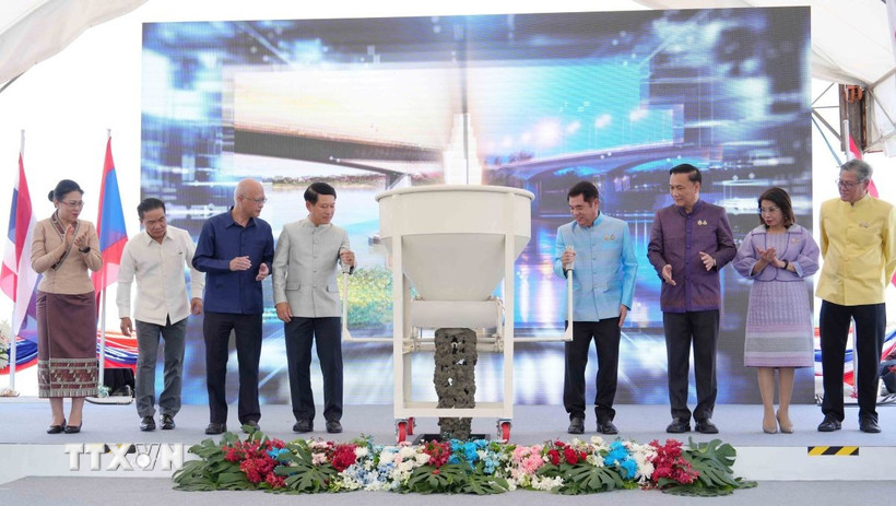 Phó Thủ tướng hai nước Lào-Thái Lan và đại diện các bộ, ngành hai nước thực hiện nghi thức đổ bê tông hợp long cầu. (Ảnh: Xuân Tú/TTXVN)