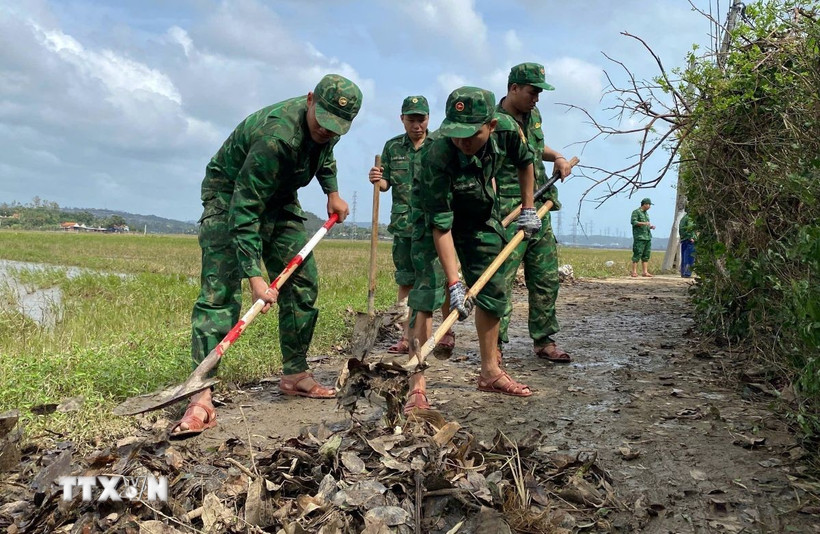 Cán bộ, chiến sỹ Đồn Biên Phòng Tuy Hòa dọn bùn đất tại phường Phú Yên để người dân đi lại thuận tiện. (Ảnh: Tường Quân/TTXVN)