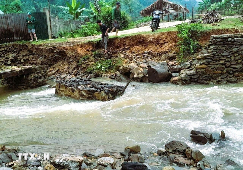 Mưa lũ gây sạt lở bờ kè, cuốn trôi rọ đá khiến cầu gỗ vào bản Na Ngân, xã Nga My (Tương Dương, Nghệ An) bị hư hỏng nặng, tạm thời chia cắt giao thông trên con đường dân sinh độc đạo. (Ảnh: TTXVN phát)