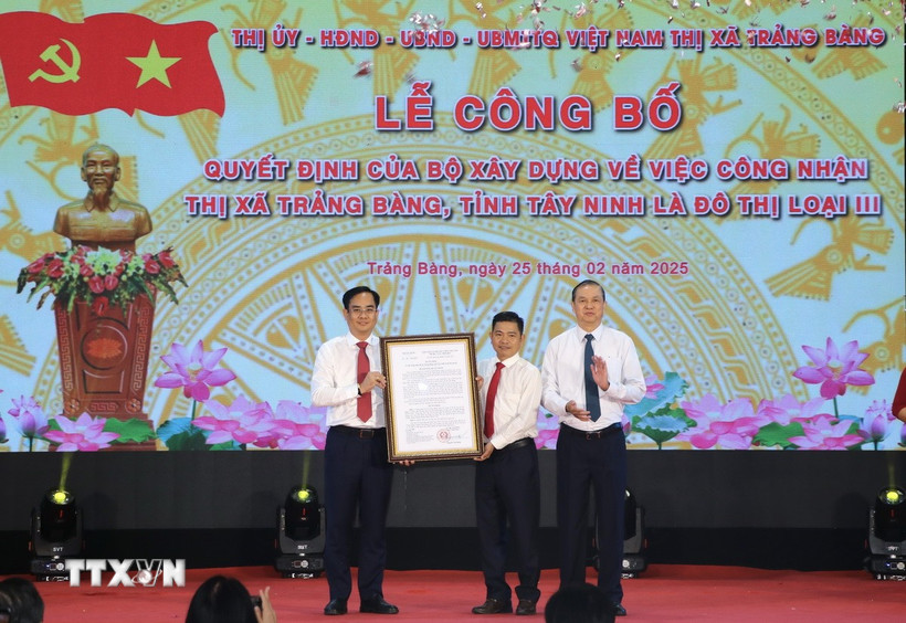 Thừa ủy quyền của Bộ trưởng Bộ Xây dựng, Phó Chủ tịch UBND tỉnh Tây Ninh Dương Văn Thắng (phải) trao Quyết định công nhận đô thị loại III cho lãnh đạo thị xã Trảng Bàng. (Ảnh: Thanh Tân/TTXVN)