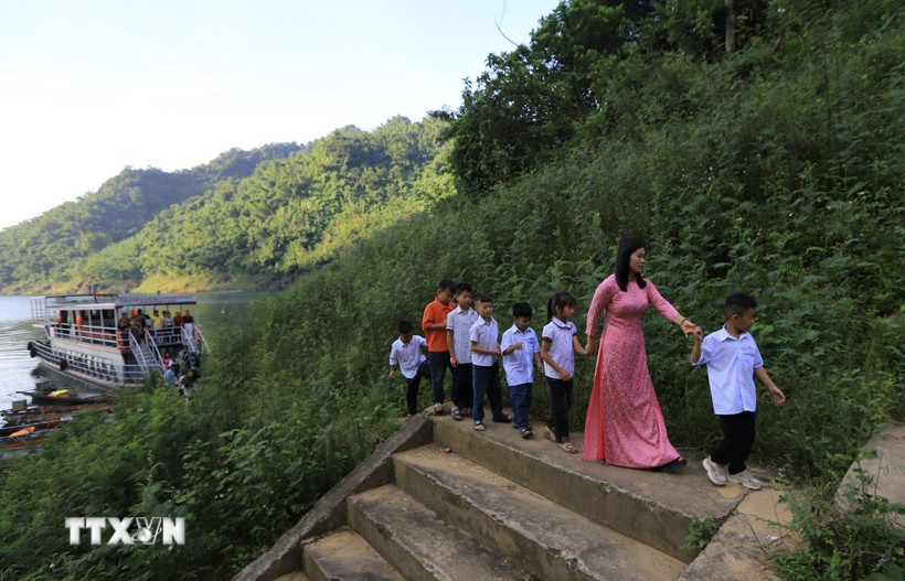 Cô giáo đón các em học sinh đến trường dự khai giảng năm học mới. (Ảnh: Trọng Đạt/TTXVN)