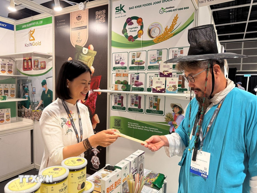 Khách tìm hiểu về sản phẩm ống hút gạo của Việt Nam. (Ảnh: Mạc Luyện/TTXVN)