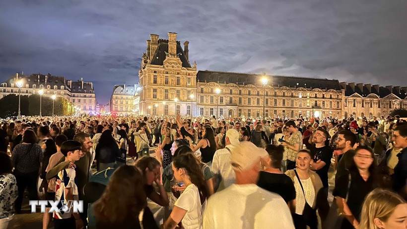 Hàng chục nghìn người tới tập trung tại vườn hoa Tuileries và bảo tàng Louvre để chứng kiến Ngọn lửa Olympic. (Ảnh: Ngọc Hiệp/TTXVN)