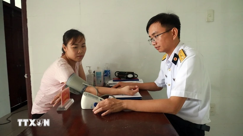 Bác sĩ tại Bệnh xá quân y đảo Sinh Tồn thăm khám cho người dân trên đảo. (Ảnh: Hữu Quyết/TTXVN)