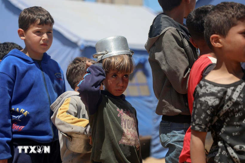 Trẻ em Palestine xếp hàng chờ được phát thực phẩm viện trợ tại Gaza ngày 19/4/2025. (Ảnh: THX/TTXVN)