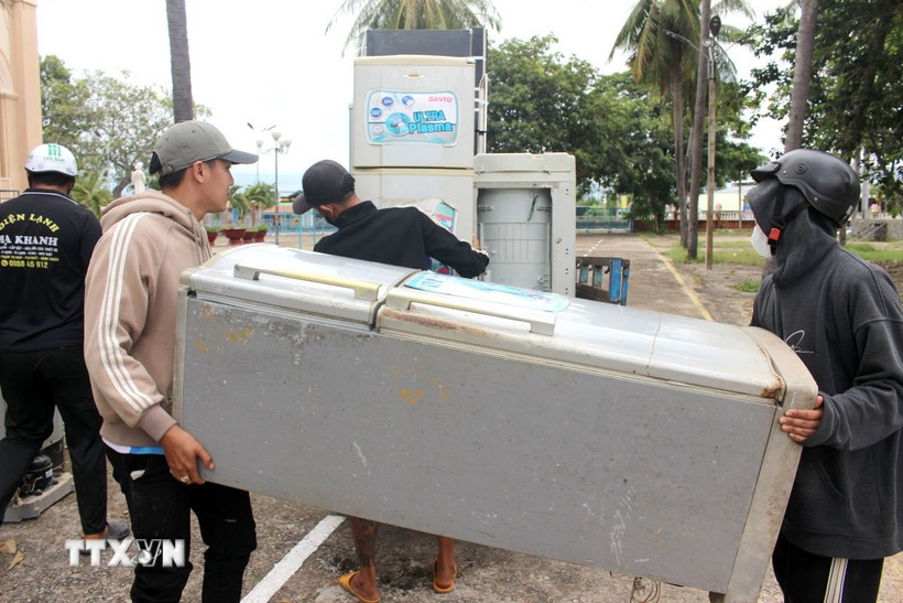 Chuyển đồ điện đã được sữa chữa về tận nhà cho người dân. (Ảnh: Nguyễn Thanh/TTXVN)