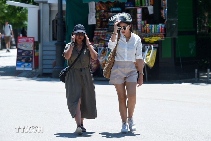 Người dân di chuyển trên đường phố dưới trời nắng nóng tại Madrid, Tây Ban Nha. (Ảnh: THX/TTXVN)