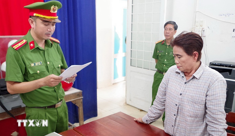 Công an thi hành Lệnh bắt tạm giam đối với bị can Lê Thị Tiền. (Ảnh: TTXVN phát)