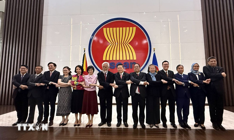 Tổng thư ký ASEAN, Thủ tướng của Timor-Leste và đại diện phái đoàn thường trực các nước ASEAN bắt tay đoàn kết tại trụ sở Ban Thư ký ASEAN. (Ảnh: Lê Minh Hưởng/TTXVN)