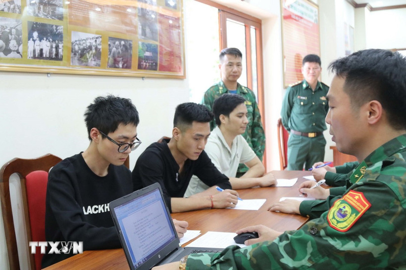 Cán bộ Đồn Biên phòng Tân Thanh (Lạng Sơn) lấy lời khai các đối tượng nhập cảnh trái phép. (Ảnh: Quang Duy/TTXVN)