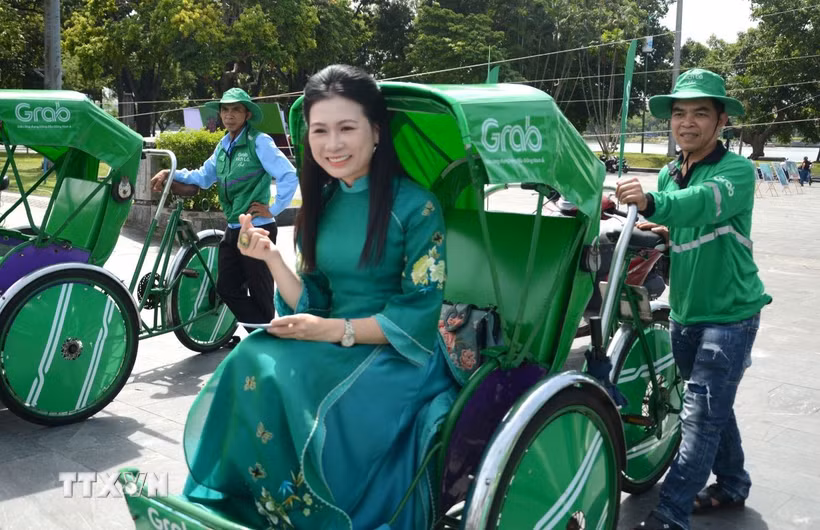 Người dân trải nghiệm mô hình dịch vụ Grab Xích lô tại Huế. (Ảnh: Văn Dũng/TTXVN)