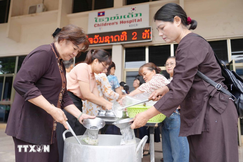 Suốt nhiều năm qua, các Phật tử chùa Phật Tích luôn duy trì bếp thiện nguyện, tự tay mang cháo tới các bệnh viện ở Lào. (Ảnh: Đỗ Bá Thành/TTXVN)