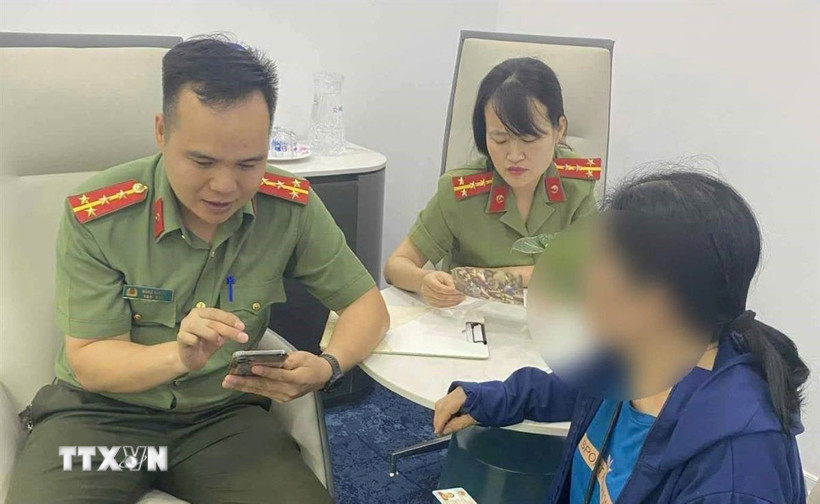 Cán bộ Phòng An ninh mạng và phòng chống tội phạm sử dụng công nghệ cao giải thích cho bà B về thủ đoạn của các đối tượng lừa đảo. (Ảnh: TTXVN phát)