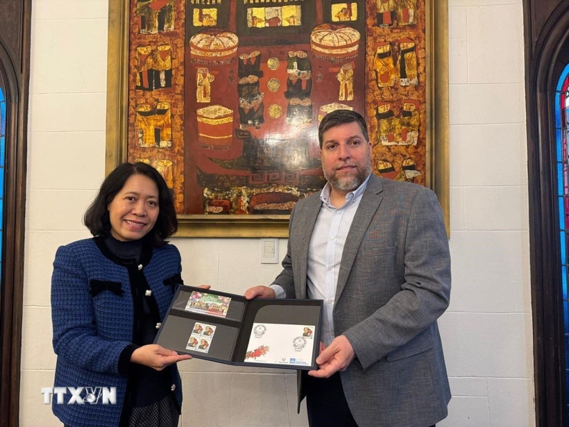 Nghị sỹ Victor Aldaya trao Đại sứ Ngô Minh Nguyệt bộ tem do Bưu chính Uruguay tháng 12/2013, nhân kỷ niệm 20 năm quan hệ ngoại giao Việt Nam-Uruguay, với chân dung của Đại tướng Võ Nguyên Giáp. (Ảnh: Diệu Hương/TTXVN) 