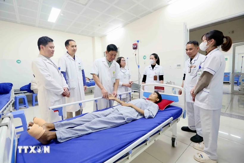 Tiến sĩ, bác sĩ Trần Hồng Vinh và đồng nghiệp thăm khám cho bệnh nhân. (Ảnh: Quang Quyết/TTXVN)