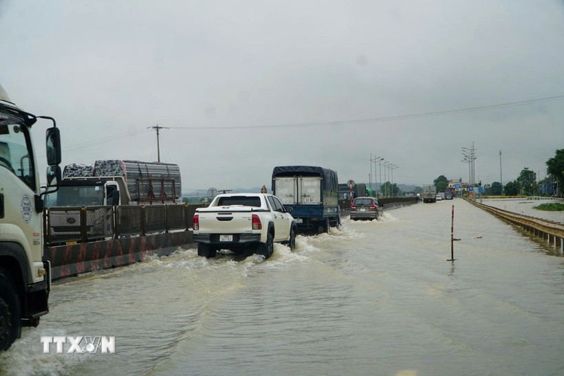 Tuyến Quốc lộ 1A đoạn qua 2 xã Hà Trung và Hoạt Giang (tỉnh Thanh Hóa) bị ngập nặng, các phương tiện lưu thông khó khăn. (Ành: Hoa Mai/TTXVN) 