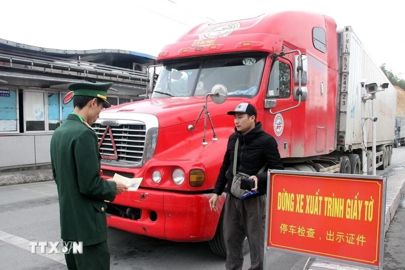 Lực lượng chức năng tại cửa khẩu quốc tế Hữu Nghị (Lạng Sơn) kiểm tra thủ tục chủ phương tiện chở hàng hóa. (Ảnh: Văn Đạt/TTXVN)