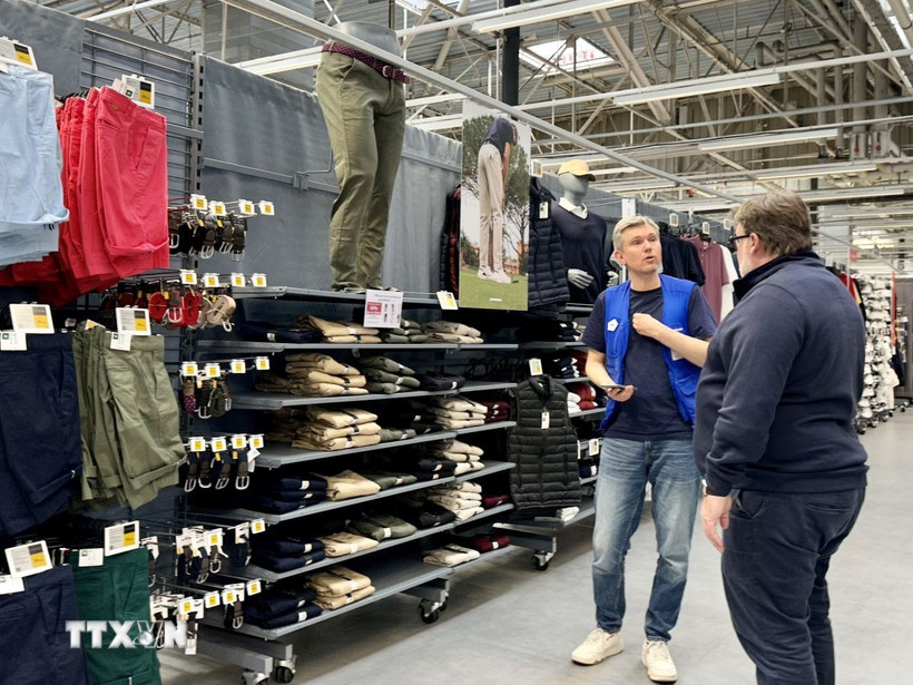 Giới thiệu quần áo thể thao "Made in Việt Nam" tới khách hàng Pháp. (Ảnh: Thu Hà/TTXVN)