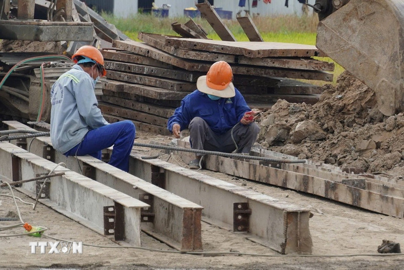 Công nhân thi công trên công trường thành phần 4 (cao tốc Châu Đốc - Cần Thơ - Sóc Trăng). (Ảnh: Tuấn Phi/TTXVN)