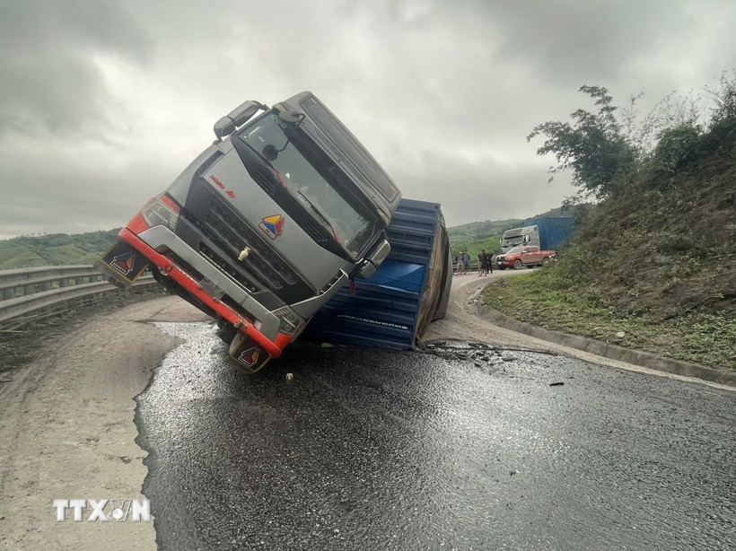 Chiếc xe chở gỗ bị lật chặn ngang khiến tuyến đường Quốc lộ 15D bị tắc nghẽn. (ảnh: TTXVN phát)
