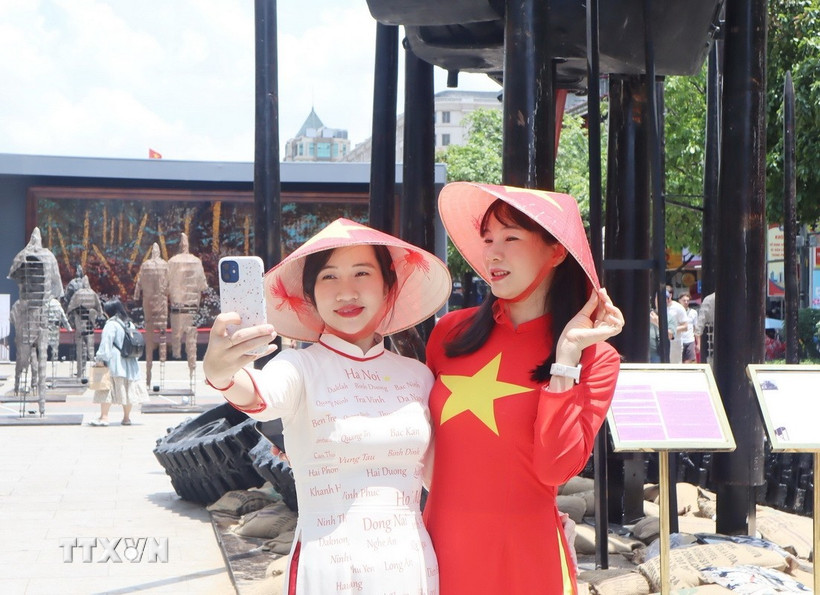 Người dân ghi lại những khoảnh khắc trong dịp lễ kỷ niệm ngày thống nhất đất nước. (Ảnh: Thu Hương/TTXVN)