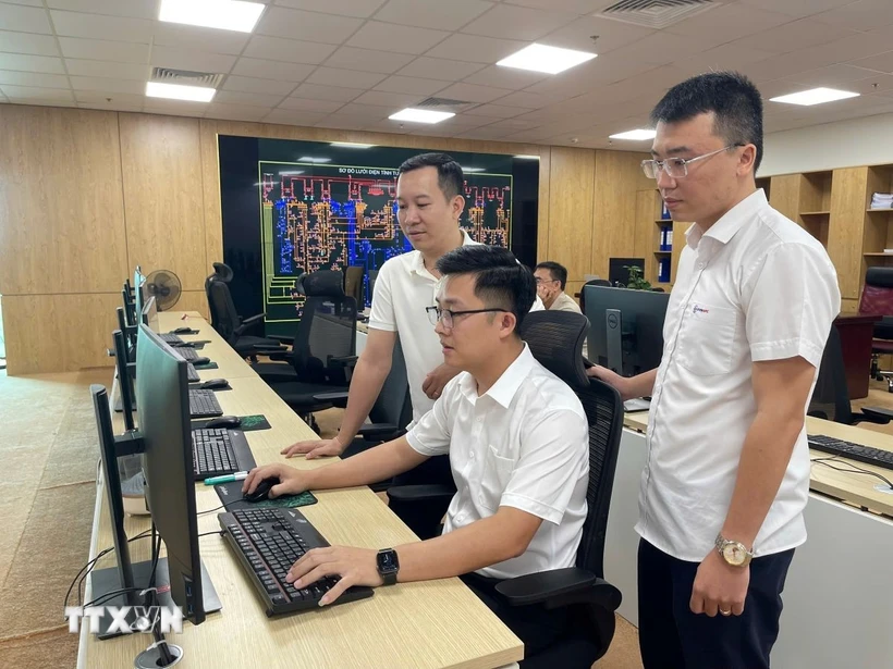 Kỹ sư Phạm Quang Tiến (ngồi giữa) cùng các đồng nghiệp đã đưa ra nhiều sáng kiến, giải pháp áp dụng tự động hóa quy trình làm việc. (Ảnh: Hoàng Hải/TTXVN)