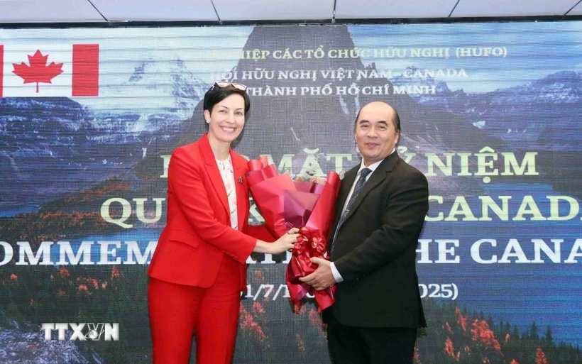 Ông Hồ Xuân Lâm, Phó Chủ tịch kiêm Tổng thư ký Liên hiệp các tổ chức hữu nghị Thành phố Hồ Chí Minh, tặng hoa chúc mừng bà Annie Dube, Tổng Lãnh sự Canada tại Thành phố Hồ Chí Minh. (Ảnh: Xuân Khu/TTXVN)